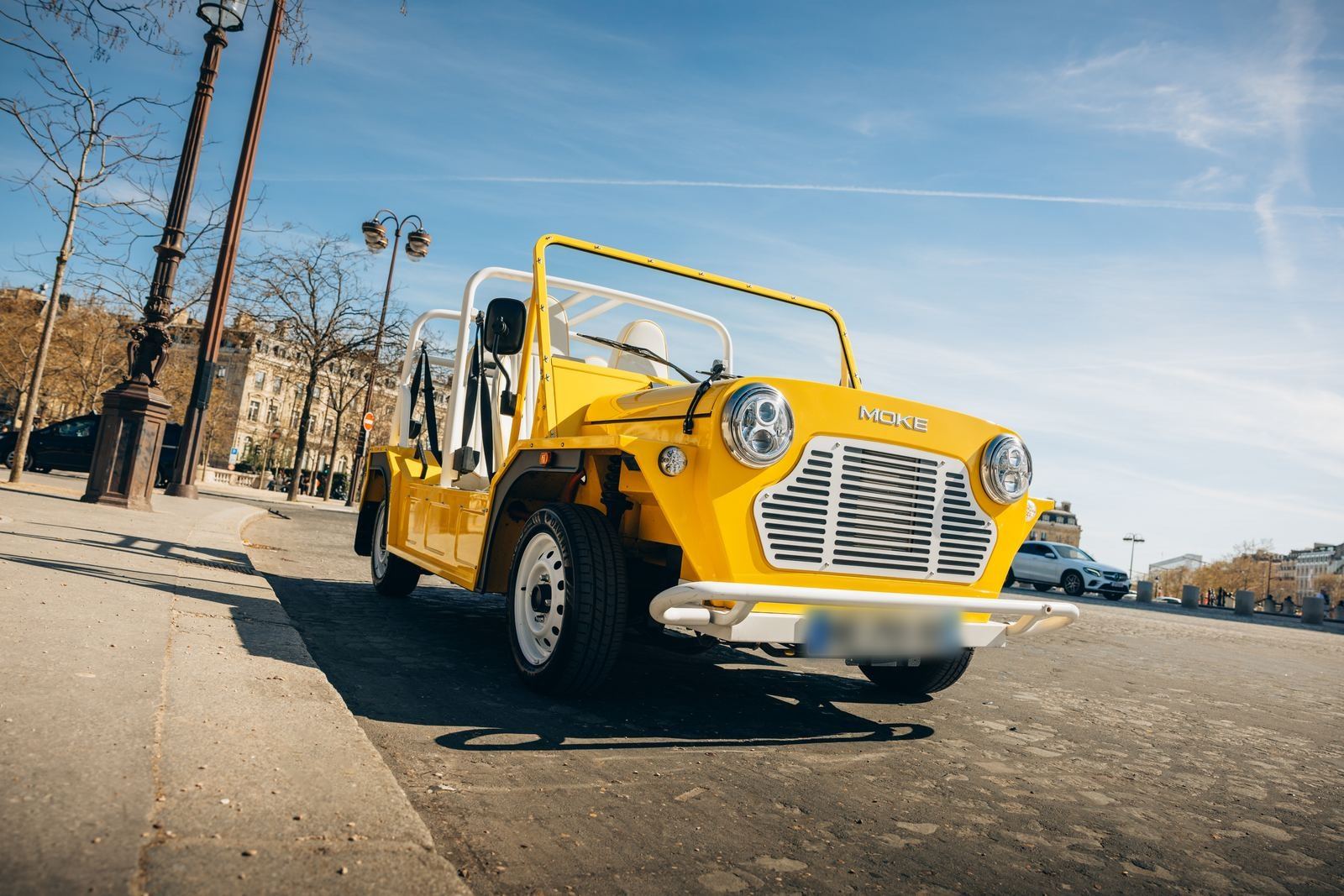Moke électrique jaune devant l'Arc de Triomphe à Paris
