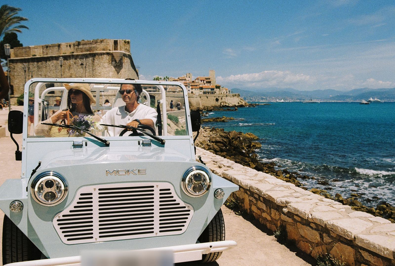 Couple en Moke électrique devant les remparts d'Antibes